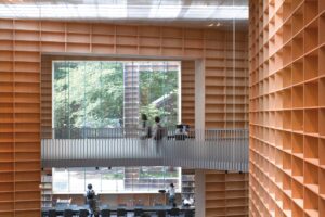 From the grand stair, Fujimoto’s ‘forest of books’ uses large apertures to connect with the cherry blossom trees that line the campus avenues