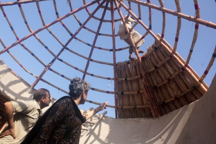 Yasmeen lari and nayeem shah look on as the roof for the disaster risk reduction centre is being put up by her team of artisans barefoot ar