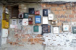 A mix of postboxes hang on the wall of a self-built neighbourhood