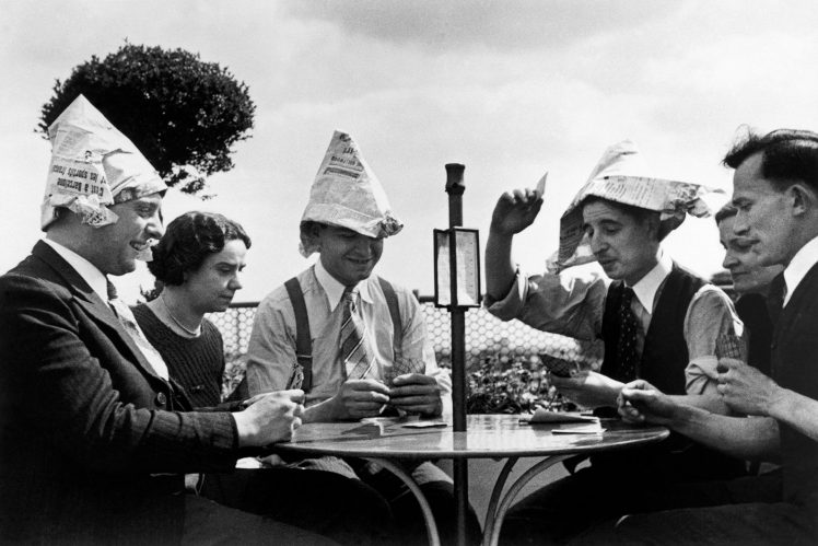 Striking workers wear paper hats and play cards on the roof of the Galeries Lafayette department store in Paris