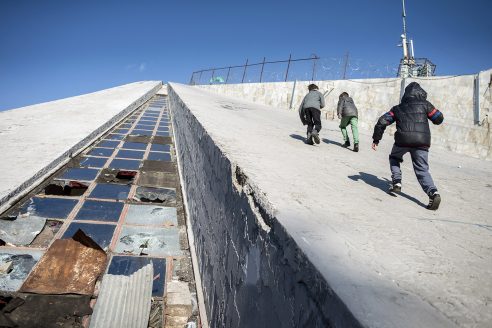 Young boys scale the roof of the Pyramid of Tirana, which is in clear need of repair with broken windows