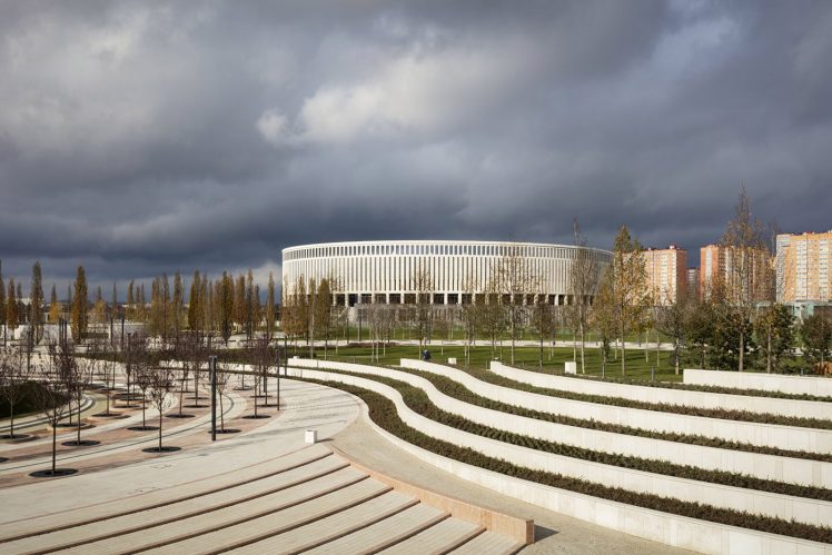The territory surrounding the Krasnodar Stadium has been extensively landscaped, with curving terraced gardens and precisely planted trees. The stadium rises in the background