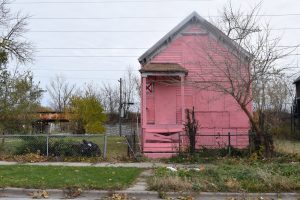 A boarded up home in Chicago is painted bright pink