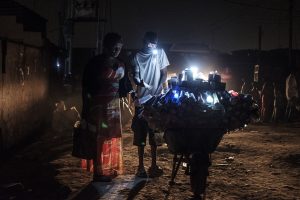 a light vendor in the Bariga neighbourhood of Lagos sells hand-held battery powered light