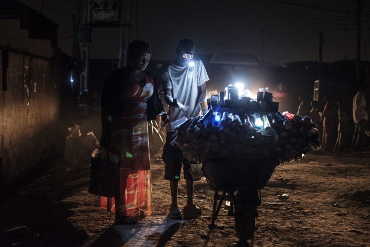 a light vendor in the Bariga neighbourhood of Lagos sells hand-held battery powered light