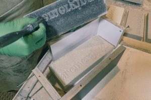 A green-gloved hand brushes a formwork mould for a brick-sized trophy for the Architectural Review AR Emerging 2023 Awards