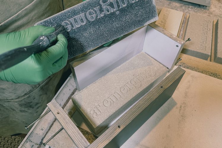 A green-gloved hand brushes a formwork mould for a brick-sized trophy for the Architectural Review AR Emerging 2023 Awards