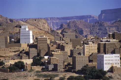 Multi-storey earthen buildings in a Yemeni desert city. There is a deep blue sky.