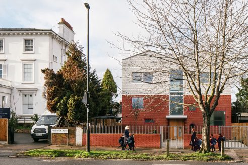 White House School's exterior front elevation facing the street. School children are walking towards the door.