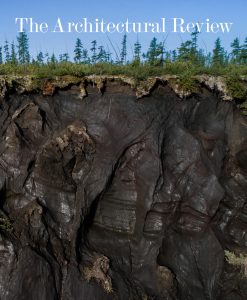 The Architectural Review Ground issue cover, September 2024, depicts a crater in Siberia formed from the collapse of melting permafrost. The photograph is by Katie Orlinsky and features a blue sky in the top 20%, then trees, grass and dark brown mud in gooey forms in the bottom two thirds of the image