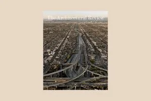Cover image of the Architectural Review June issue on roads, on a coloured background. The cover is a photograph of a wide freeway in Los Angeles cutting through the city's suburbs