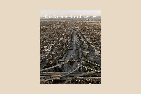 Cover image of the Architectural Review June issue on roads, on a coloured background. The cover is a photograph of a wide freeway in Los Angeles cutting through the city's suburbs