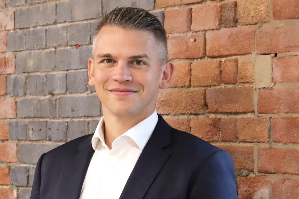 Headshot of Martin Staehr, Group managing director of Kier’s Construction business, standing against a brick wall