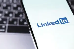 Image of a mobile showing the linkedin logo, on top of a keyboard