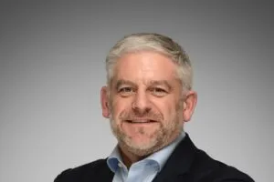 Headshot of Simon Bourne on grey background