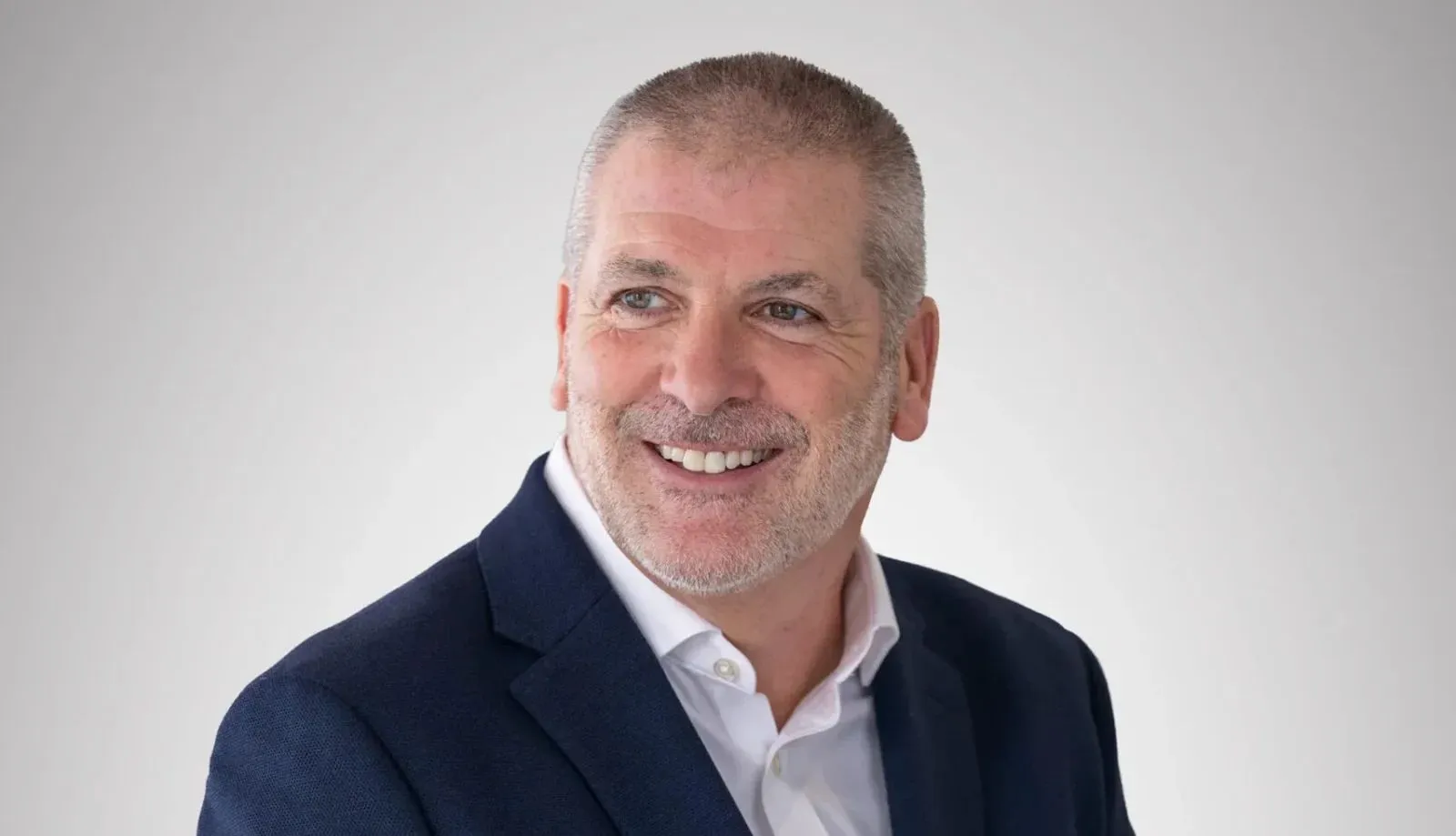 A man in suit smiling - Jason Warren from Collins Construction