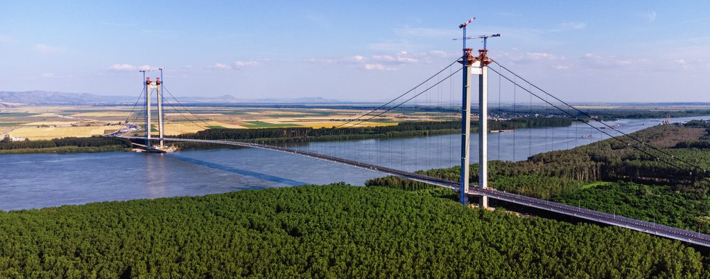 WeBuild, along with an international consortium, has successfully finished constructing the Braila Bridge in Romania, which spans the Danube River. With a cost of €500M (£427M), the bridge now holds the title of being the second longest suspension bridge on mainland Europe.